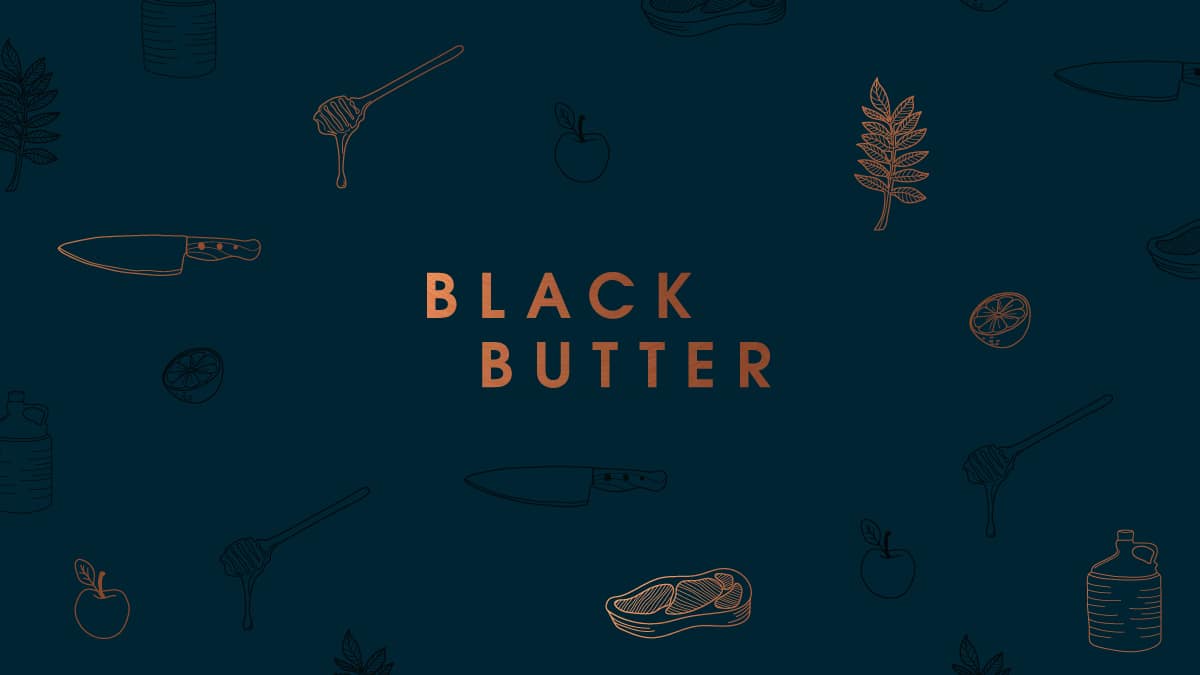 The Black Butter logo. Displayed in the brand colour pf copper and set in capital letters. The background is a dark teal. There are brand illustrations surrounding the logo which include a liquorice leaf, a lemon cut in half, a honey drizzler with honey dripping off, a chef's knife, a steak, an apple and a cider demijohn.