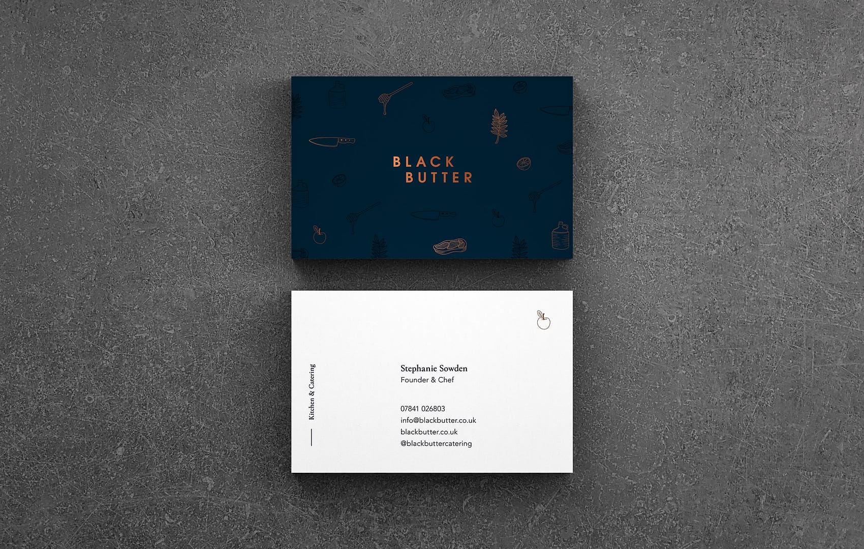 A duplex business card for Black Butter. The logo is displayed in copper foil on the front on a dark teal card stock. Brand illustrations subtly Frame the logo. The reverse displays contact information on a white card stock.