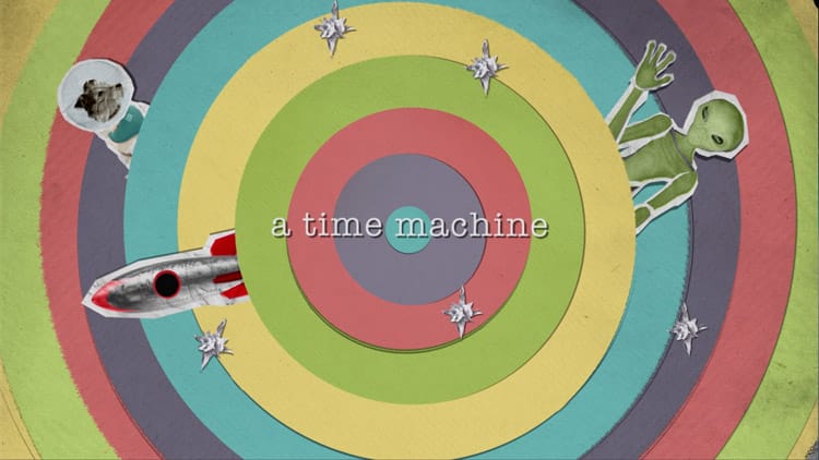 Animation still showing a collage-stye scene of a time warp depicted by multiple paper circles nested inside each other. Popping out of 3 of the rings is an alien, a dog in a space helmet and a rocket. There are also stars made out of foil scattered over the the circles. The text reads “a time machine”.