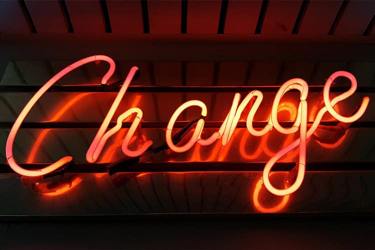 An orange neon light spelling the word "Change" on a dark background.